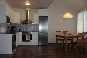 a kitchen with a table and a stainless steel refrigerator at Holiday Houses Saimaa Gardens in Imatra