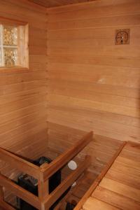 a sauna with wooden walls and a wooden floor at Holiday Houses Saimaa Gardens in Imatra