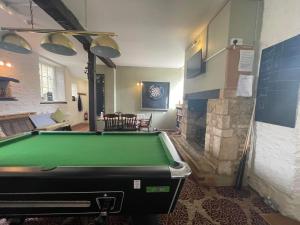 a pool table in a room with a fireplace at The Bell Inn in Oxford