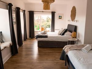a bedroom with two beds and a window at Pure Magic Lodge in Slievemore