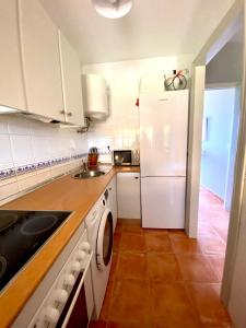 a kitchen with a white refrigerator and a dishwasher at Ático Islantilla Golf in Islantilla