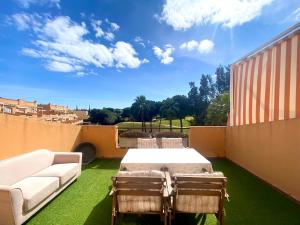 a patio with a couch and a table and chairs at Ático Islantilla Golf in Islantilla
