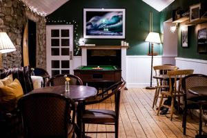 a dining room with a pool table and a fireplace at Pure Magic Lodge in Slievemore