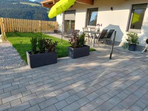 a patio with three potted plants and a table at Ferienwohnung Pölvenblick in Söll