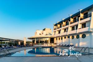 un hôtel avec une piscine en face d'un bâtiment dans l'établissement Hotel Mon Jardin, à Mahmudia