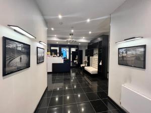a hallway with white walls and black tile floors at Great St Helen Hotel in London