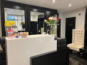 a white counter with a vase of flowers on it at Great St Helen Hotel in London