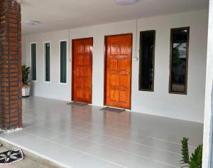 two wooden doors in a room with a tile floor at บ้านอยู่สบาย บึงโขงหลง in Ban Don Klang