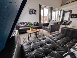 - un salon avec des canapés en cuir noir et une table dans l'établissement Woonhotel Petruskerk, à Flessingue