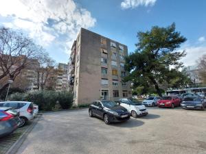 a parking lot with cars parked in front of a building at Split apartment in Split