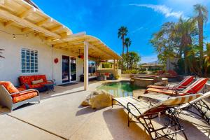 une terrasse avec des chaises et une piscine dans une maison dans l'établissement Life by the Palms Permit# 50342, à Indio