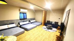 1 dormitorio con 2 camas y TV. en 舞浪海景旅店, en Xiaoliuqiu