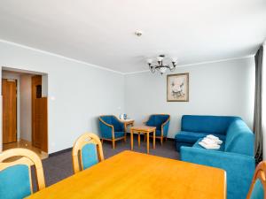 a living room with a blue couch and a table at Hyrny in Zakopane