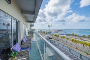 a balcony with chairs and a view of the beach at Oceanview Paradise In The One Happy Island in Oranjestad
