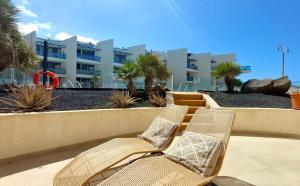 two wicker chairs sitting on a patio in front of a building at Beach Suite Cotillo by Sea You There Fuerteventura in Cotillo