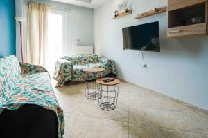 a living room with a couch and a table and a tv at Neochori House in Antimácheia