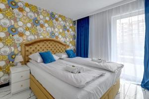 グダニスクにあるWAVE APARTMENTS-GOLD EXCLUSIVEのベッドルーム1室(大型ベッド1台、青と白の枕付)