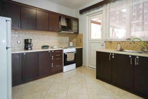 a kitchen with brown cabinets and a white refrigerator at Neochori House in Antimácheia