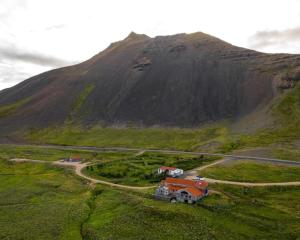 a house on a road in front of a mountain at ÖXL Snæfellsnes in Snæfellsbær