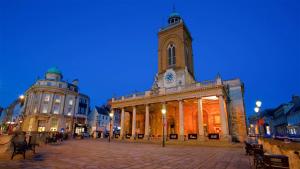 a building with a tower with a clock on it at Market-Side King Bed Suite in Northampton