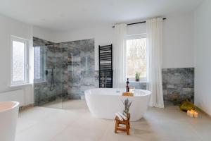 a large white bathroom with a tub and a shower at CHALET627 in Braunlage +52 photos