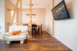 uma sala de estar com uma cadeira branca e uma televisão de ecrã plano em CHALET627 em Braunlage