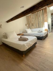 two beds in a room with wooden floors at Duplex place des lices in Saint-Tropez