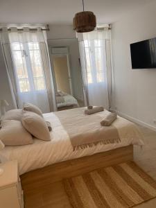 a large bed in a bedroom with a mirror at Duplex place des lices in Saint-Tropez