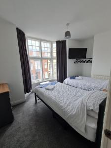 a bedroom with two beds and a large window at Yorkshire Rose in Scarborough
