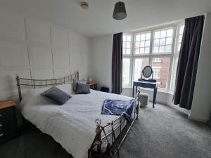 a bedroom with a bed and a large window at Yorkshire Rose in Scarborough