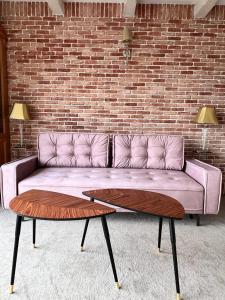 a purple couch in a room with a brick wall at Hotel-Przystań in Kikół