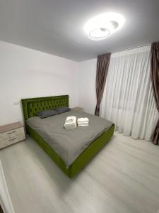 a bedroom with a bed with two towels on it at PH16 in Piatra Neamţ