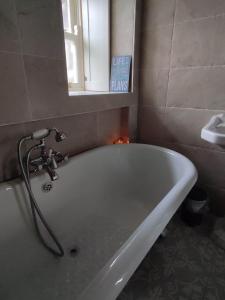 a bath tub in a bathroom with a sink at The Old House at Belfield in Tralee