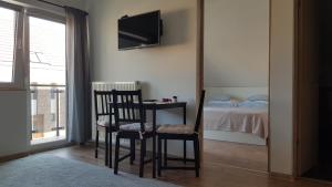 - une chambre avec un lit, une chaise et une télévision dans l'établissement Végvár Delux apartman, à Gyula