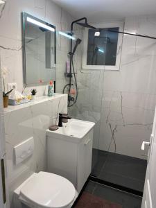 a white bathroom with a toilet and a sink at PH16 in Piatra Neamţ