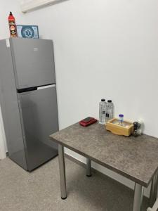 a table next to a refrigerator in a room at PH16 in Piatra Neamţ