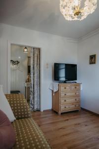 a living room with a television on a wooden dresser at Das kleine Haus in Breitenbrunn