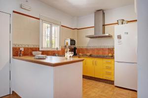 Casa Nesenka 1 في زاهورا: مطبخ فيه دواليب صفراء وثلاجة بيضاء