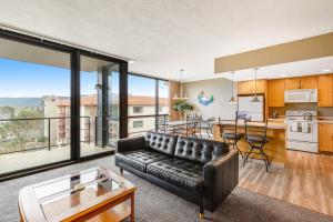 a living room with a leather couch and a kitchen at Sand & Sea: Neawanna Creek (414) in Seaside