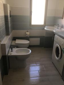 Appartamenti Manuela في كالا غونوني: حمام مع مرحاض ومغسلة وغسالة