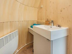 uma casa de banho com um lavatório branco e uma ventoinha em Tinyhouse 2 em Heringsdorf