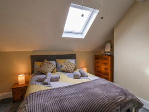 Schlafzimmer mit einem großen Bett und einem Dachfenster in der Unterkunft Yorkshire House in Filey