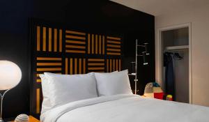 a bedroom with a white bed with a black headboard at Renaissance Des Moines Savery Hotel in Des Moines