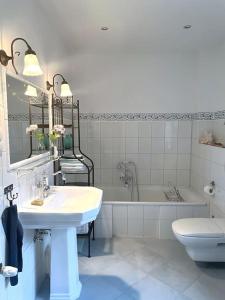 ein Badezimmer mit einem Waschbecken, einer Badewanne und einem WC in der Unterkunft Ferienhaus Schlossstraße in Kühlungsborn