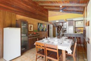a dining room with a table and a refrigerator at Casa Aconchegante e Inteligente na Cachoeira in Florianópolis