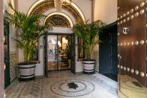 une entrée à un bâtiment avec des plantes en pot dans l'établissement Hotel Casa Palacio Don Ramón, à Séville