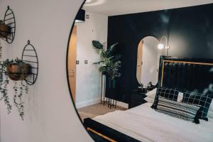 a bedroom with a bed with a large mirror at Penthouse Noir - Wyndale Living - Central BHam 2BR in Birmingham