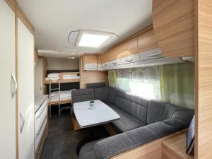 a living room with a couch and a table in a caravan at Mietwohnwagen 01 in Heringsdorf