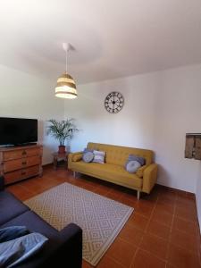 a living room with a couch and a clock on the wall at Pine 3 Inn, holiday home, activities and more in Boavista dos Pinheiros