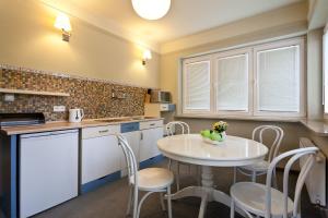 a kitchen with a table and chairs and a sink at Apartamenty Willa Kazimierz in Krakow